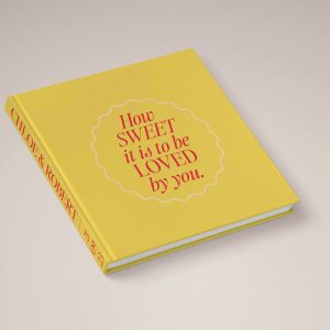 Luxe Wedding Photo Album with fun creative cover design in yellow & pink colours with lyrics extract How Sweet It Is To Be Loved By You. Yellow photo album cover perfect for a gold or yellow wedding colour palette.
