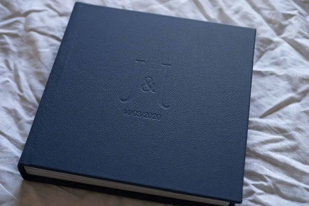Square photo album for wedding photos with a leather cover in a navy blue colour and custom lettering