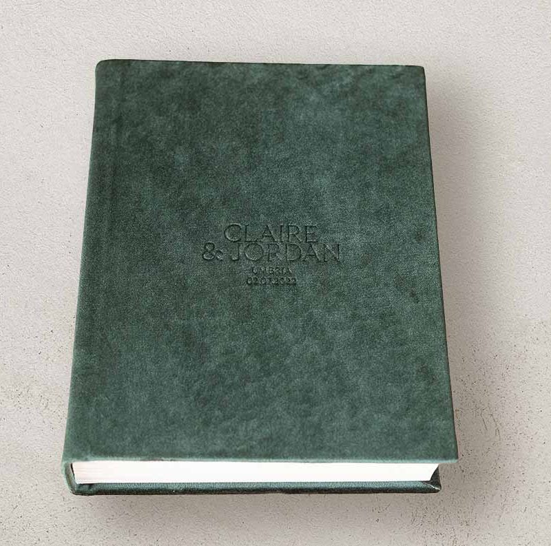 Portrait photo album for wedding photos with a velvet cover in a emerald green colour and custom lettering. Green wedding colour theme.